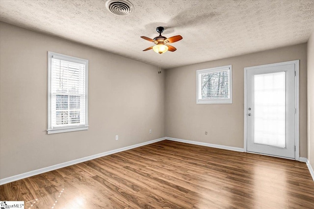 empty room with hardwood / wood-style flooring, a textured ceiling, and ceiling fan