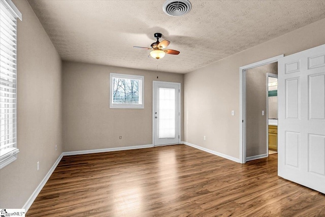 interior space with dark wood-type flooring, a textured ceiling, and ceiling fan