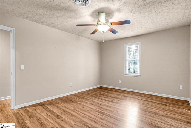 unfurnished room with a textured ceiling, light hardwood / wood-style floors, and ceiling fan