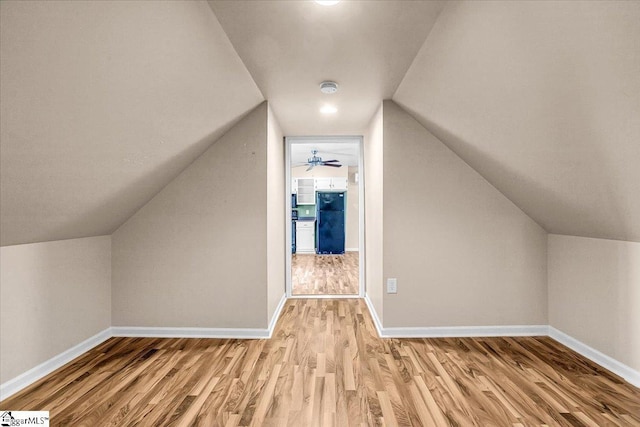 bonus room with lofted ceiling and light wood-type flooring