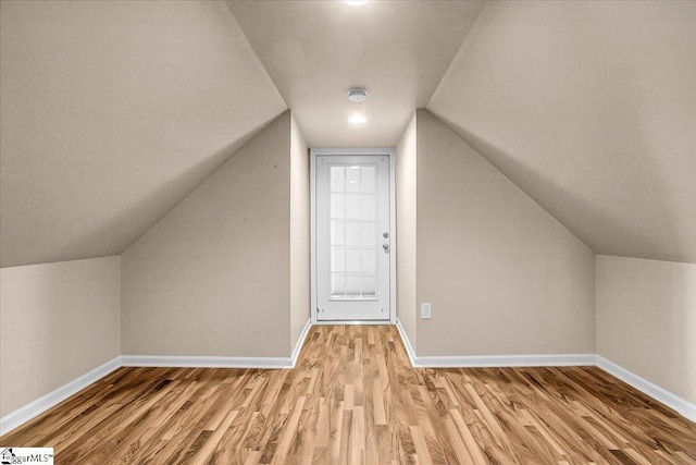 bonus room featuring vaulted ceiling and light wood-type flooring