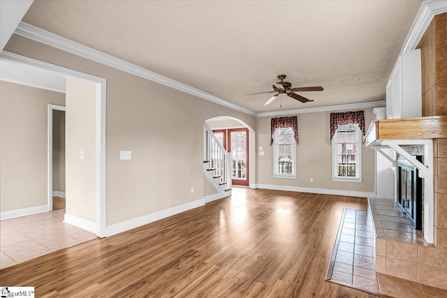 unfurnished living room with ornamental molding, light hardwood / wood-style floors, and a tile fireplace