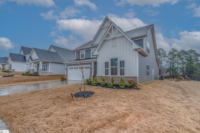 view of front of property featuring central AC, a garage, and a front lawn