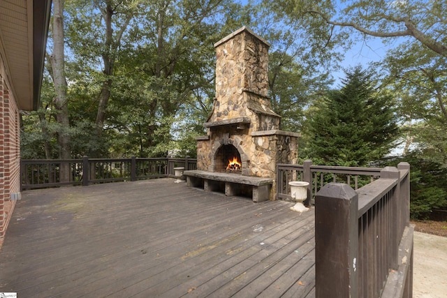 deck with an outdoor stone fireplace