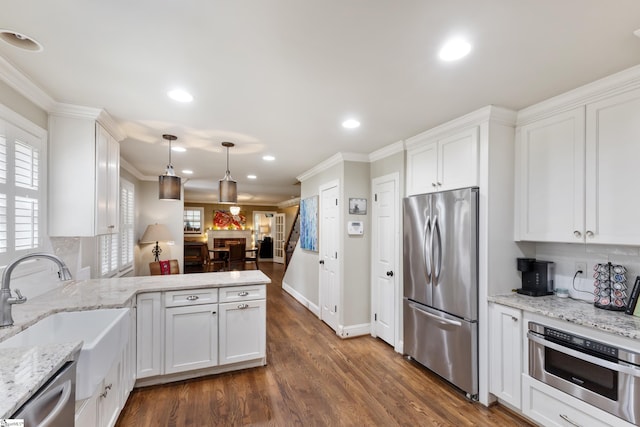 kitchen featuring stainless steel appliances, white cabinetry, ornamental molding, and sink