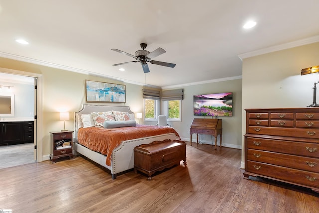 bedroom with crown molding, hardwood / wood-style floors, ceiling fan, and ensuite bath