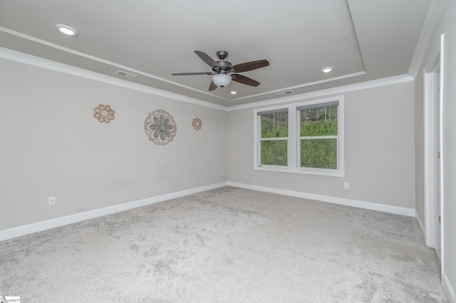 spare room featuring ornamental molding, light colored carpet, ceiling fan, and a tray ceiling