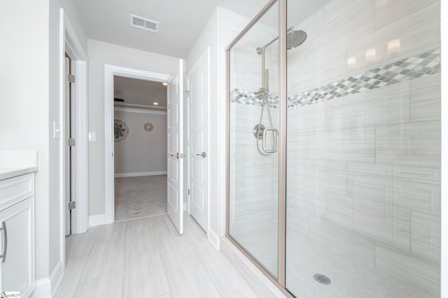 bathroom featuring vanity and a shower with door