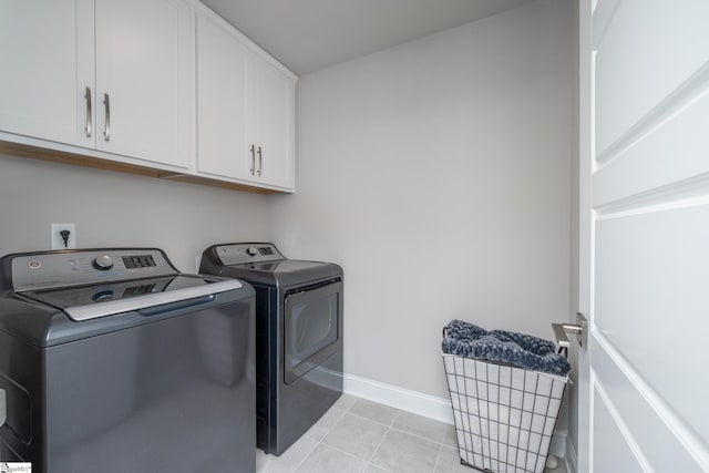 laundry room featuring independent washer and dryer, cabinets, and light tile patterned flooring