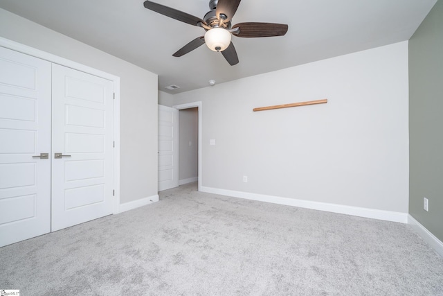 unfurnished bedroom with light carpet, ceiling fan, and a closet