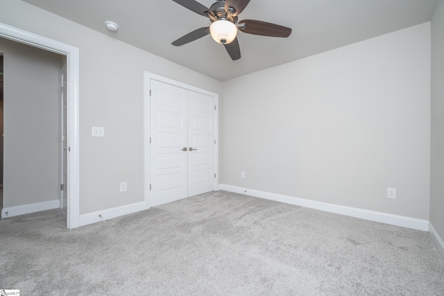 unfurnished bedroom featuring light carpet, ceiling fan, and a closet