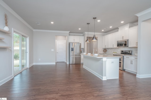 kitchen with pendant lighting, dark wood-type flooring, appliances with stainless steel finishes, white cabinets, and a center island with sink