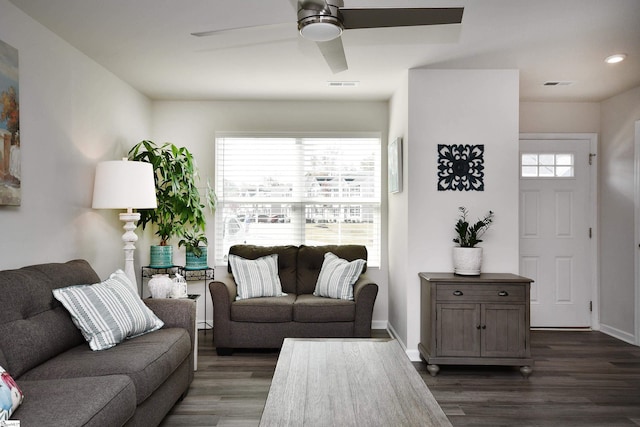 living room with dark wood-type flooring and ceiling fan