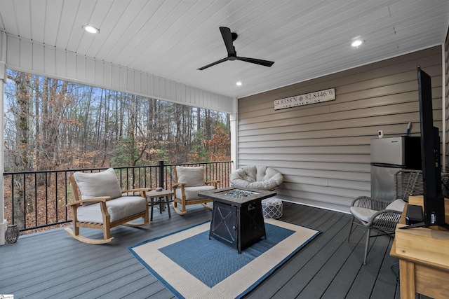 wooden deck featuring an outdoor living space with a fire pit and ceiling fan