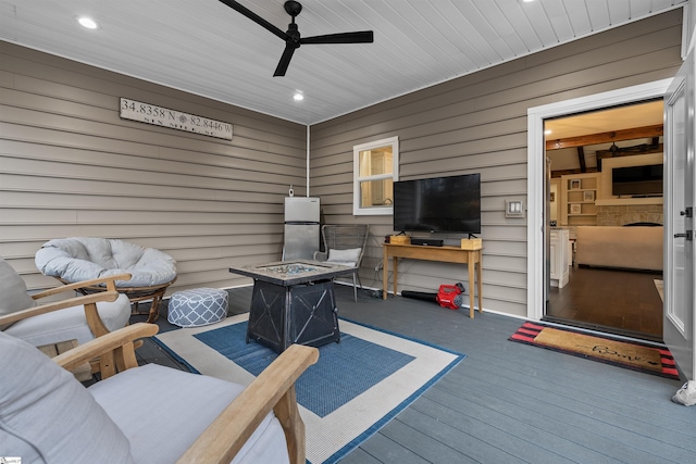 wooden terrace featuring ceiling fan and an outdoor fire pit