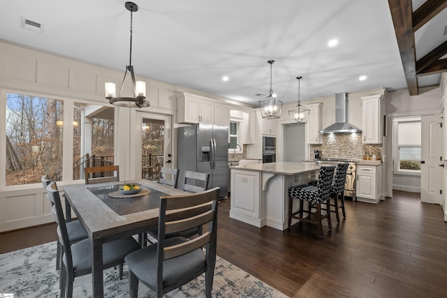 dining room with sink, an inviting chandelier, and dark hardwood / wood-style flooring