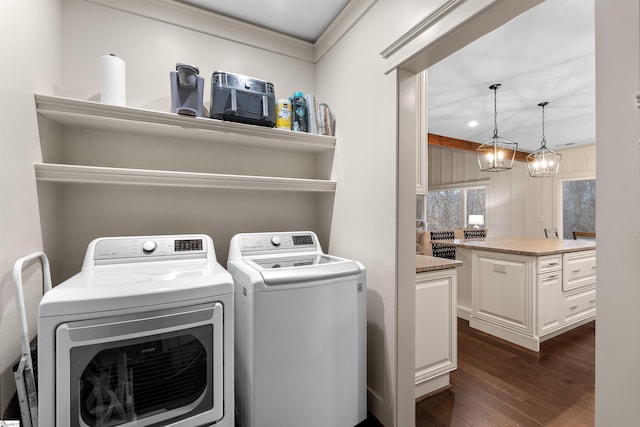 clothes washing area with dark hardwood / wood-style floors, an inviting chandelier, and independent washer and dryer