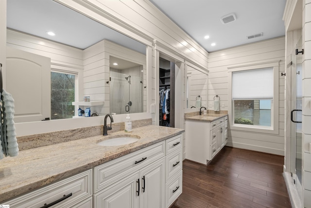 bathroom featuring vanity, plenty of natural light, wood-type flooring, and walk in shower