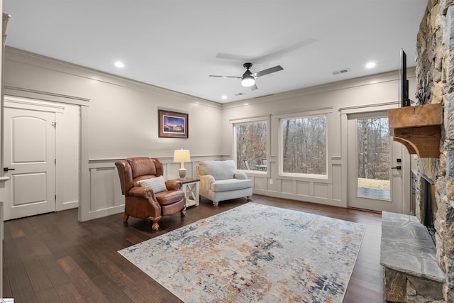 sitting room featuring dark hardwood / wood-style flooring, crown molding, a fireplace, and ceiling fan