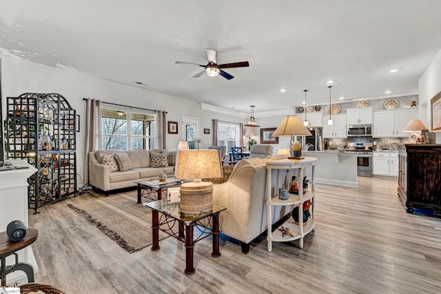 living room featuring ceiling fan and light hardwood / wood-style floors