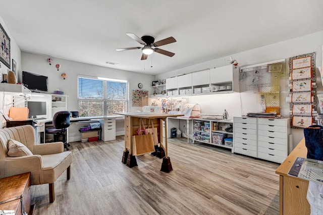 home office with ceiling fan and light hardwood / wood-style flooring