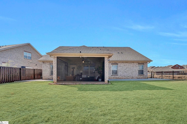 back of house with a yard, a sunroom, and ceiling fan