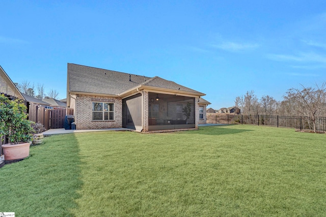 rear view of house with a sunroom and a yard