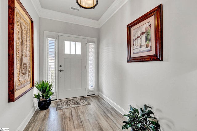 foyer with crown molding and light hardwood / wood-style floors