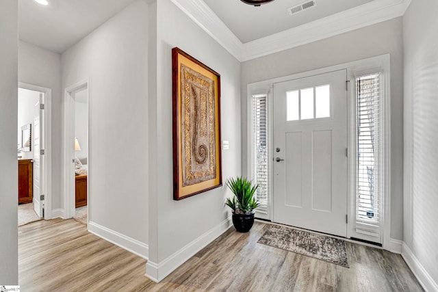 entrance foyer featuring crown molding and light wood-type flooring