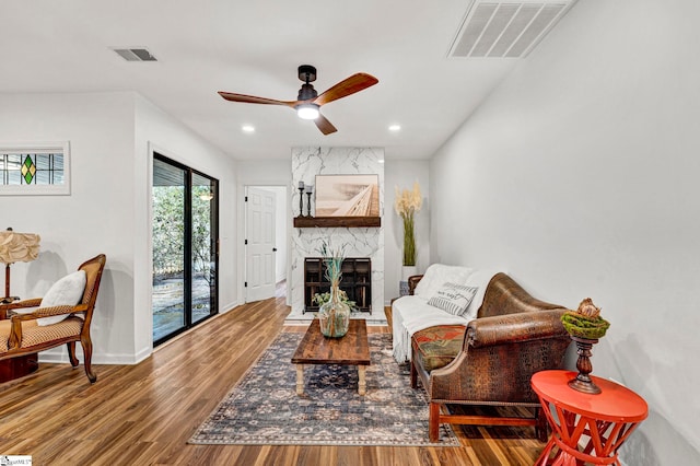 living room featuring hardwood / wood-style floors, a fireplace, and ceiling fan