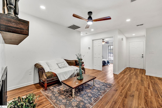 living room with wood-type flooring and ceiling fan