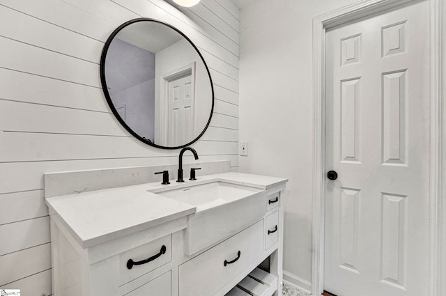 bathroom featuring vanity and wooden walls