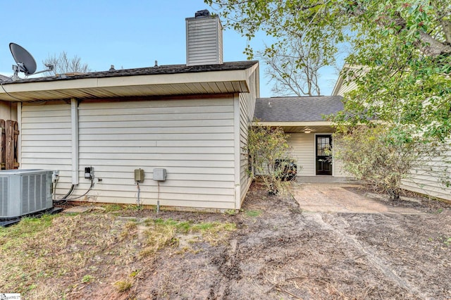 rear view of property with central AC