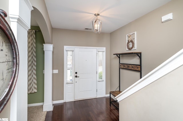 entryway featuring dark wood-type flooring and decorative columns