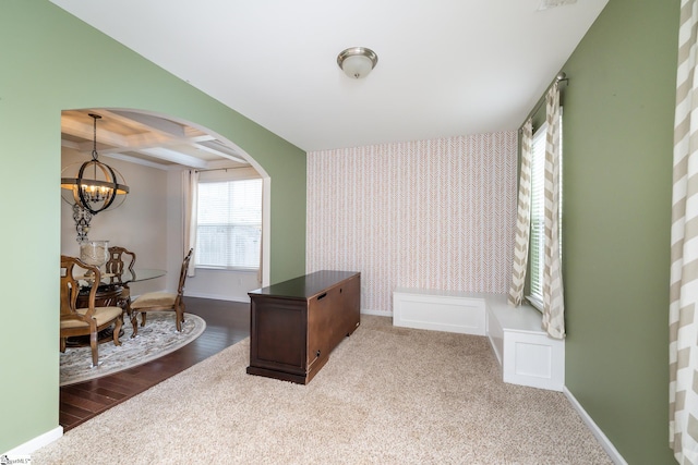 office space with carpet, coffered ceiling, a notable chandelier, and beam ceiling