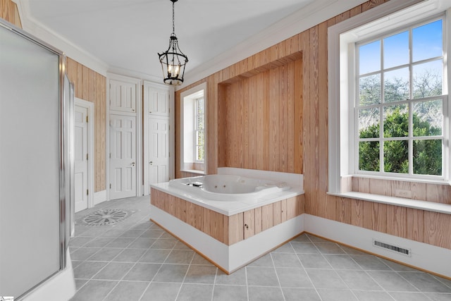 bathroom with a washtub, wooden walls, and tile patterned floors