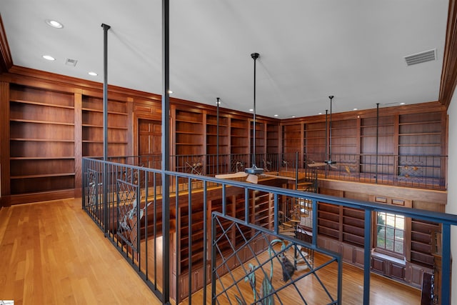 hallway featuring ornamental molding and light hardwood / wood-style flooring