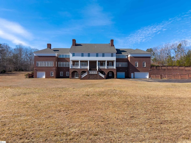 rear view of house with a garage and a yard