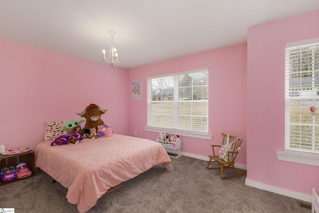 carpeted bedroom with multiple windows and a chandelier