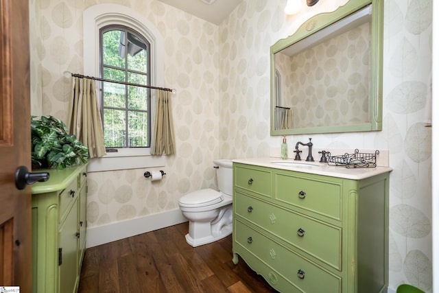 bathroom with wood-type flooring, toilet, and vanity