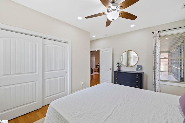 bedroom featuring light hardwood / wood-style flooring, ceiling fan, and a closet