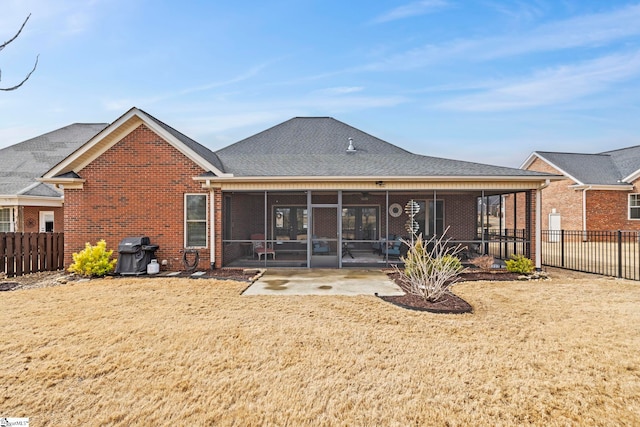 rear view of house featuring a yard, a patio area, and a sunroom