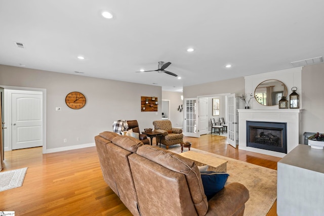 living room with light hardwood / wood-style flooring, french doors, and ceiling fan