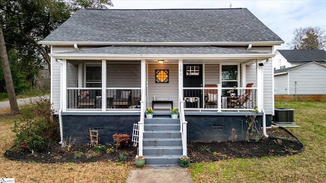 bungalow-style house with a porch, roof with shingles, and cooling unit