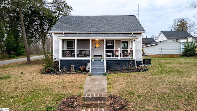 bungalow-style home featuring a porch, a front yard, a shingled roof, and central AC unit