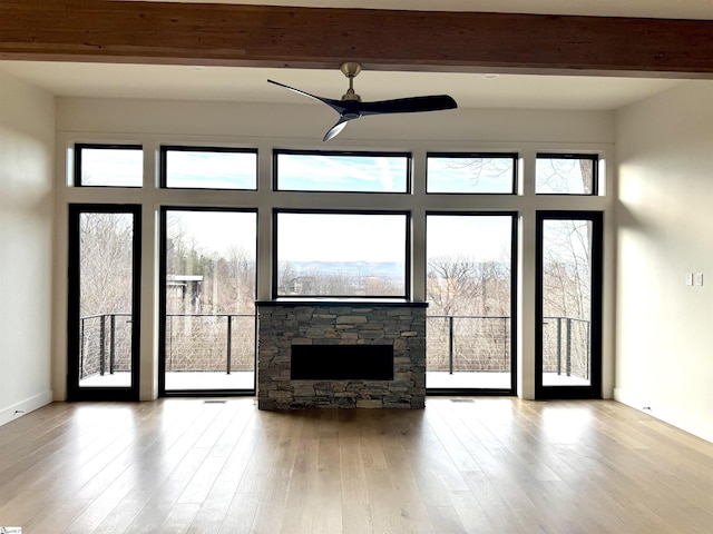 unfurnished living room featuring beamed ceiling, ceiling fan, and light hardwood / wood-style flooring