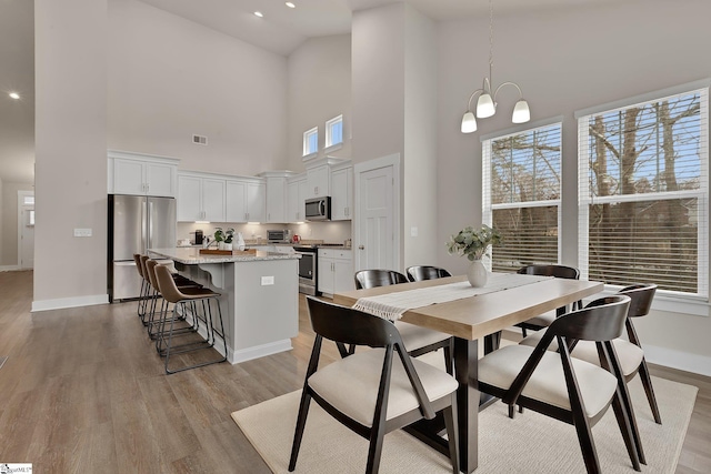 dining space featuring an inviting chandelier and light hardwood / wood-style floors