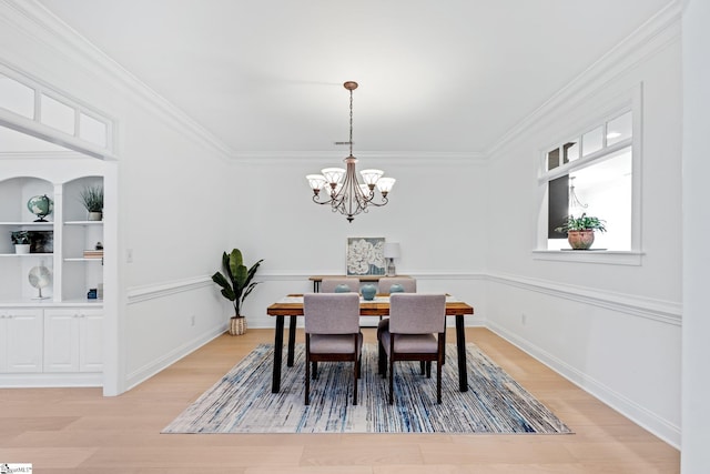 dining area with ornamental molding, wood-type flooring, and a chandelier