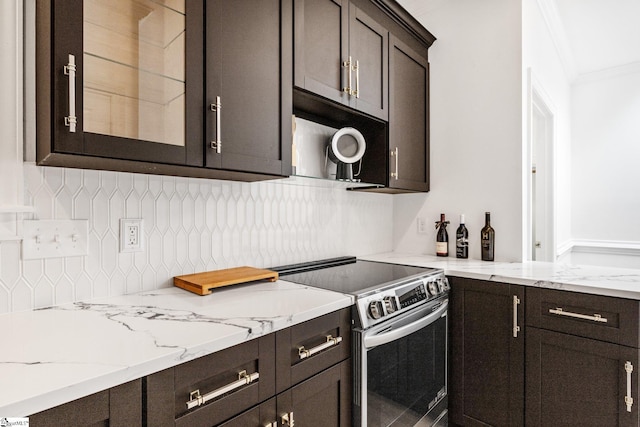 kitchen with dark brown cabinetry, crown molding, tasteful backsplash, and stainless steel electric range oven