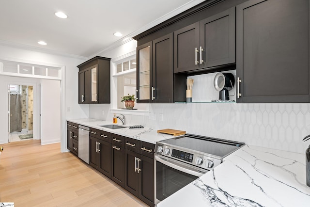 kitchen featuring appliances with stainless steel finishes, sink, backsplash, light stone counters, and crown molding